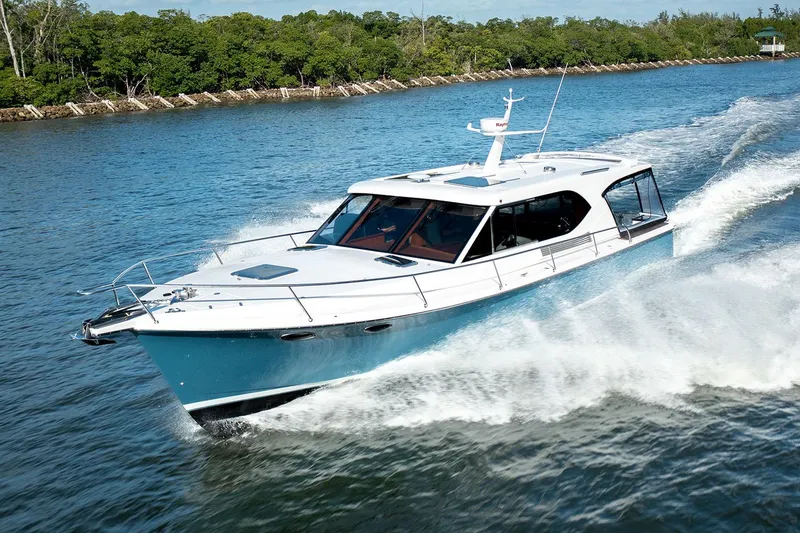 Slide: The Image of Manufacturer Provided Image: 2025 Hylas M49 yacht cruising on a scenic waterway, surrounded by lush greenery. - 4