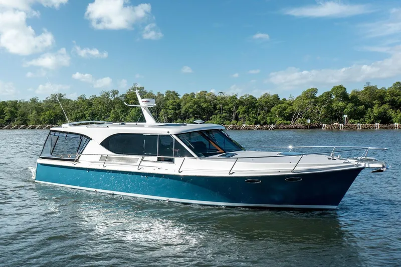 Slide: The Image of Manufacturer Provided Image: 2025 Hylas M49 yacht cruising on a sunny day, surrounded by lush greenery. - 5