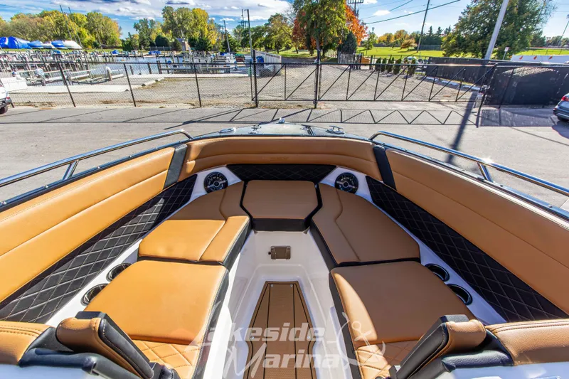 Slide: The Image of 2026 Chaparral SSX 6 boat interior with tan seating and black accents at a marina. - 29