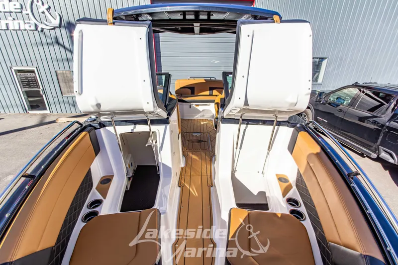 Slide: The Image of 2026 Chaparral SSX 6 boat interior with tan seating and open storage compartments. - 36