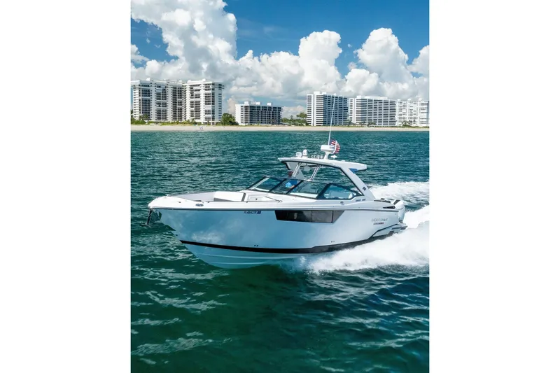 The Image of 2026 Monterey 385SS Super Sport cruising on ocean near modern beachfront buildings. - 1
