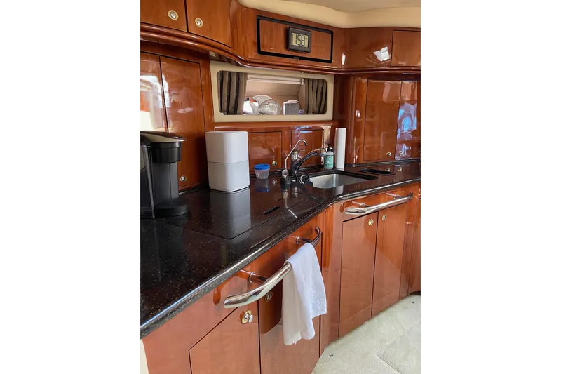 Slide: The Image of Luxurious 2003 Sea Ray 550 Sundancer yacht kitchen with sleek wood cabinetry and modern appliances. - 13