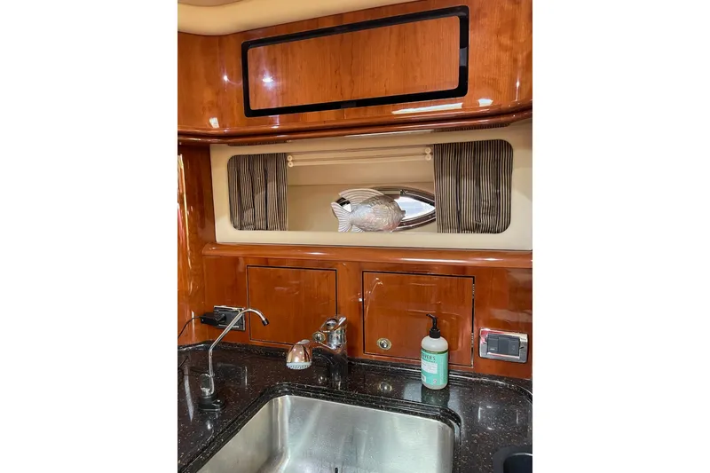 Slide: The Image of Luxurious 2003 Sea Ray 550 Sundancer yacht interior with polished wood cabinetry and modern sink. - 15