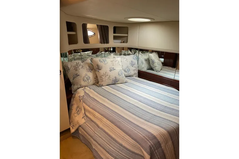 Slide: The Image of Cozy bedroom in 2003 Sea Ray 550 Sundancer yacht with striped bedding and mirrored wall. - 23