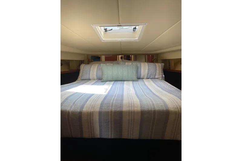 Slide: The Image of Cozy bedroom interior of 2003 Sea Ray 550 Sundancer yacht with striped bedding. - 24