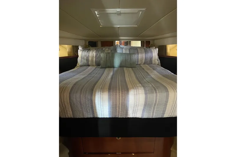 Slide: The Image of Cozy bedroom interior of 2003 Sea Ray 550 Sundancer yacht with striped bedding. - 25