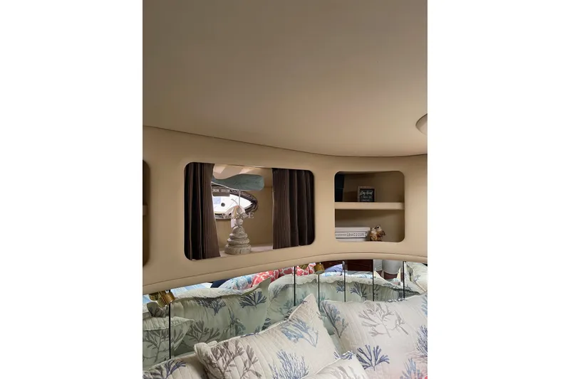 Slide: The Image of Interior of 2003 Sea Ray 550 Sundancer with cozy bedding and decorative shelves. - 29