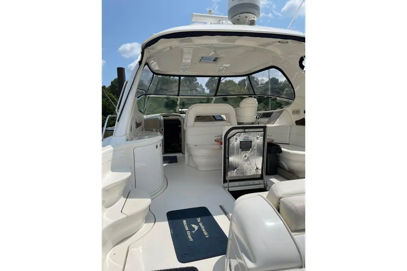 Slide: The Image of 2003 Sea Ray 550 Sundancer yacht interior with seating and helm, under a clear sky. - 9