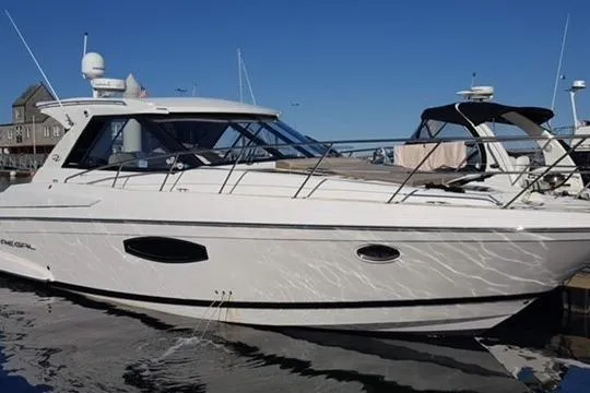 Slide: The Image of 2013 Regal 42 Sport Coupe yacht docked in a marina under clear blue skies. - 12