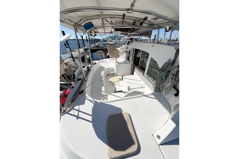 Slide: The Image of 2005 Lagoon 380 S2 catamaran deck with seating and marina view. - 11