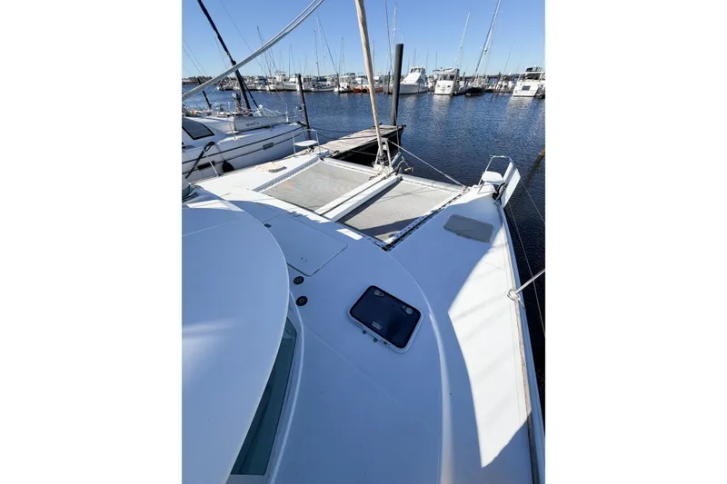Slide: The Image of 2005 Lagoon 380 S2 catamaran docked at marina, surrounded by sailboats. - 14