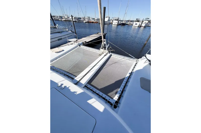 Slide: The Image of 2005 Lagoon 380 S2 catamaran docked at marina, featuring netted deck area. - 15