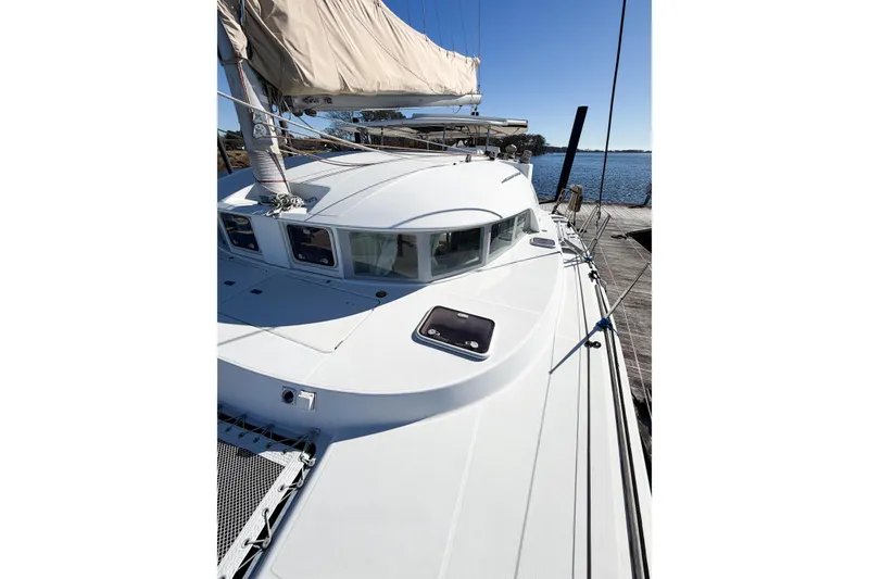 Slide: The Image of 2005 Lagoon 380 S2 catamaran docked, showcasing sleek design and spacious deck. - 17