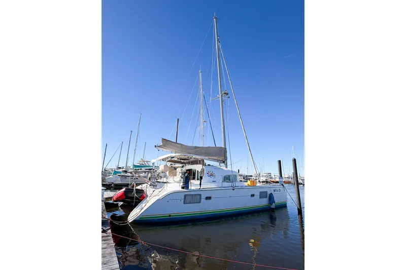 Slide: The Image of 2005 Lagoon 380 S2 catamaran docked at marina under clear blue sky. - 2