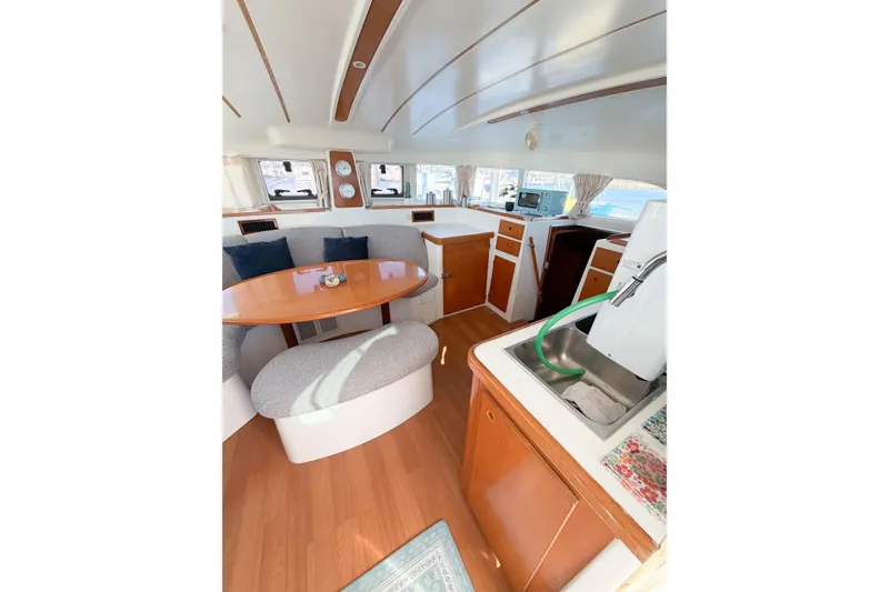 Slide: The Image of Interior of 2005 Lagoon 380 S2 catamaran with dining area and kitchenette. - 22