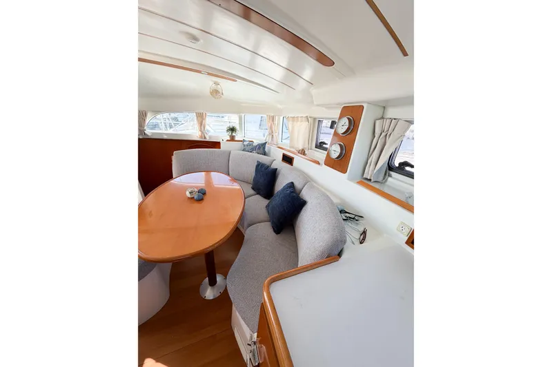 Slide: The Image of Interior of 2005 Lagoon 380 S2 yacht with cozy seating and elegant wooden table. - 24