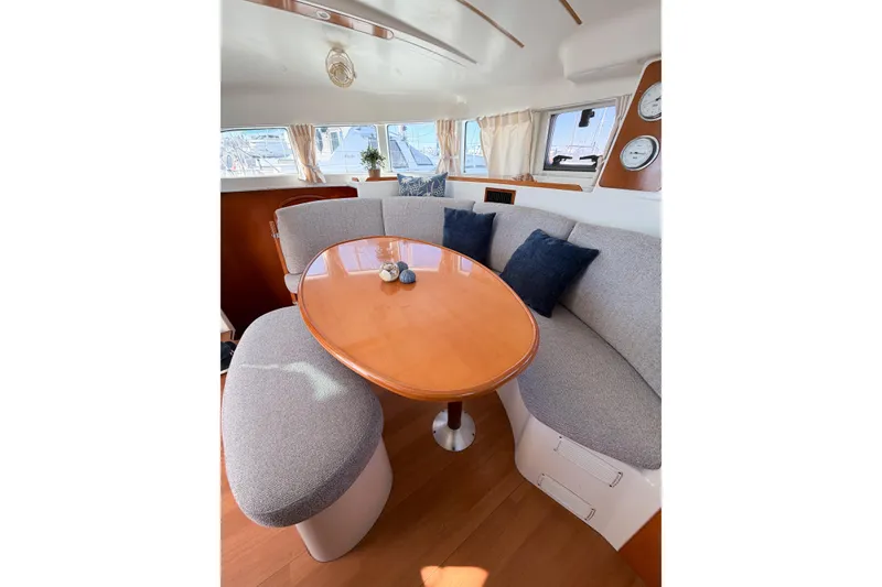Slide: The Image of Interior of 2005 Lagoon 380 S2 yacht with cozy seating and wooden table. - 25