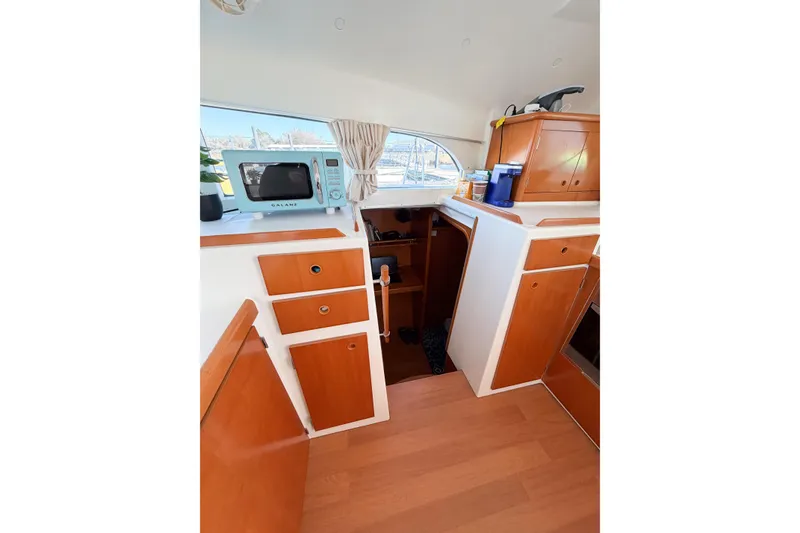Slide: The Image of Interior of 2005 Lagoon 380 S2 yacht kitchen with microwave and wooden cabinets. - 26