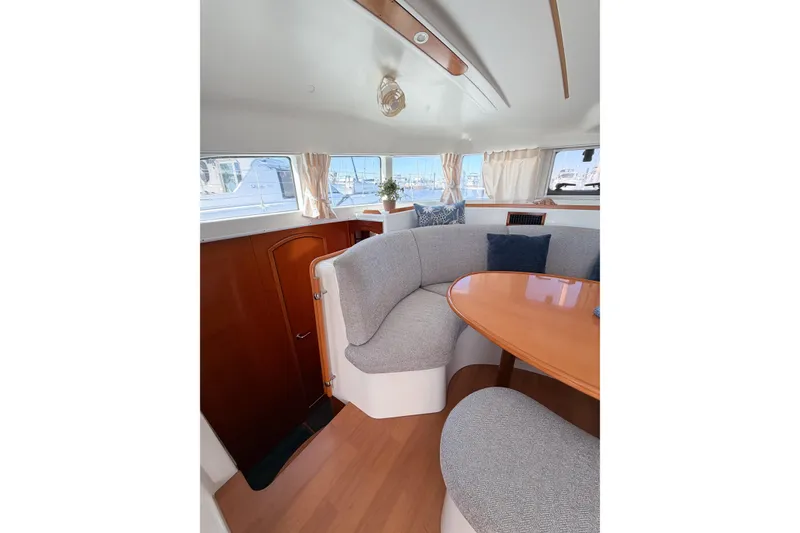 Slide: The Image of Interior of 2005 Lagoon 380 S2 yacht with cozy seating and wooden table. - 27
