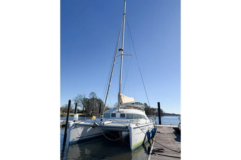 Slide: The Image of 2005 Lagoon 380 S2 catamaran docked under clear blue sky. - 3