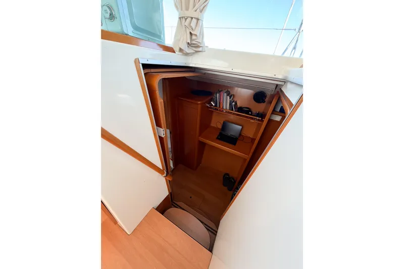 Slide: The Image of Interior view of 2005 Lagoon 380 S2 sailboat cabin with wooden shelves and equipment. - 30