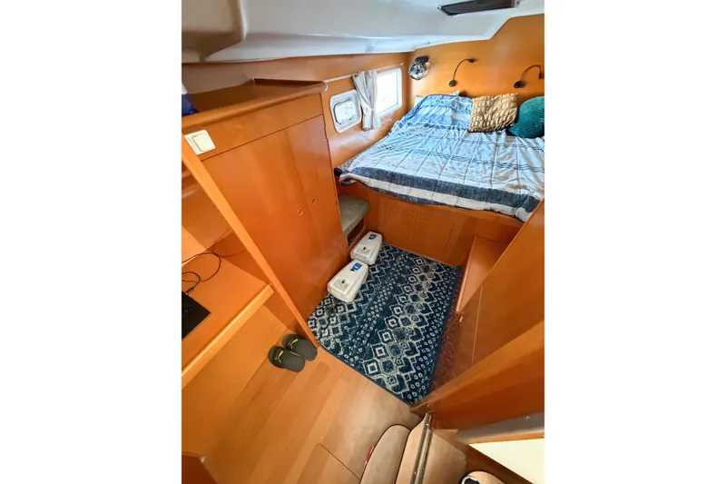 Slide: The Image of Interior cabin of 2005 Lagoon 380 S2 catamaran with cozy bed and wooden furnishings. - 31