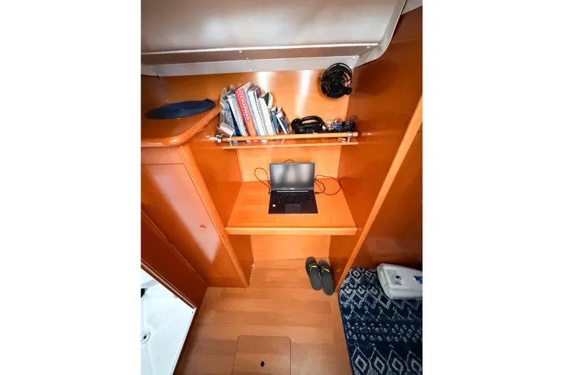 Slide: The Image of Interior of 2005 Lagoon 380 S2 yacht with laptop, books, and shoes. - 33