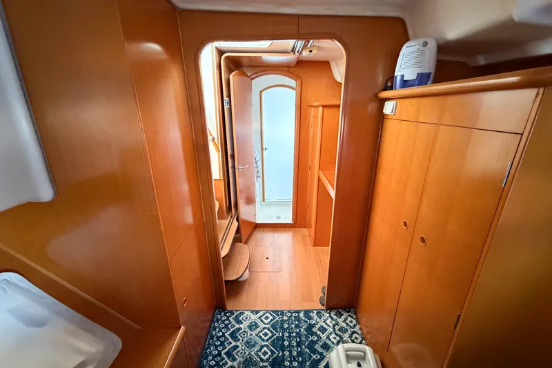 Slide: The Image of Interior of 2005 Lagoon 380 S2 yacht with wooden cabinetry and blue patterned rug. - 37