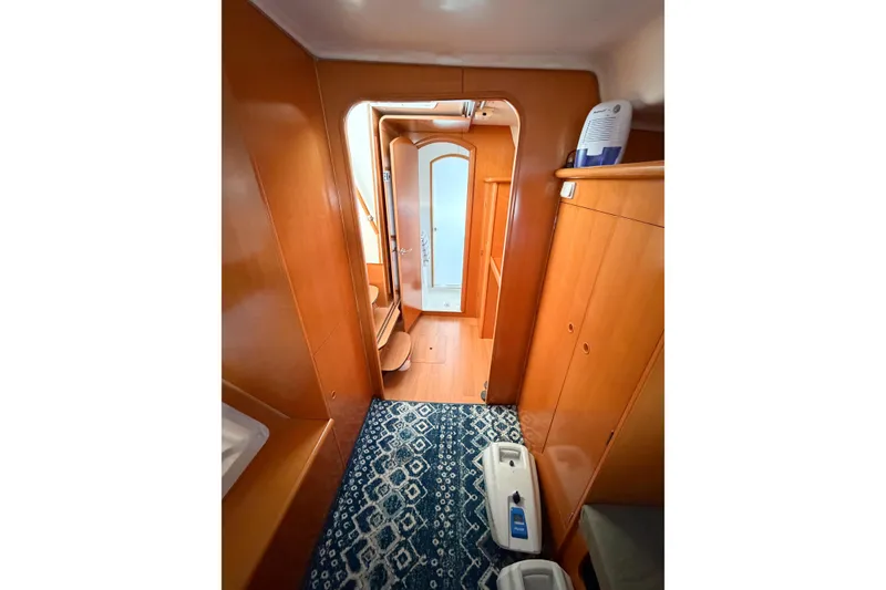 Slide: The Image of Interior of 2005 Lagoon 380 S2 yacht with wooden cabinetry and patterned rug. - 38