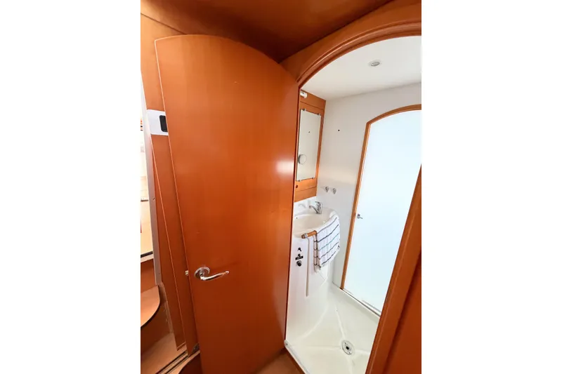 Slide: The Image of Interior of 2005 Lagoon 380 S2 yacht bathroom with wooden door and compact sink. - 41