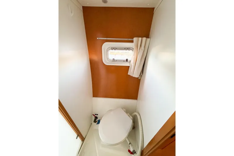 Slide: The Image of 2005 Lagoon 380 S2 yacht bathroom with window and compact toilet. - 48