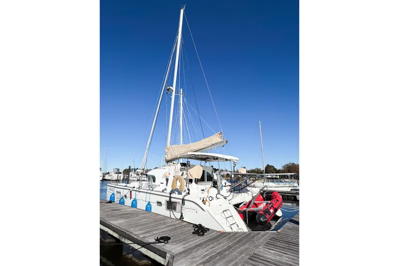Slide: The Image of 2005 Lagoon 380 S2 catamaran docked at marina under clear blue sky. - 5
