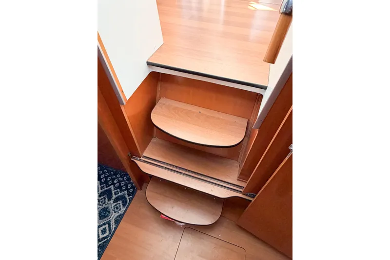 Slide: The Image of Wooden interior stairs of a 2005 Lagoon 380 S2 catamaran. - 50