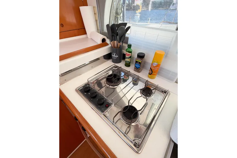 Slide: The Image of Compact kitchen area in a 2005 Lagoon 380 S2 yacht with stove and cooking essentials. - 51