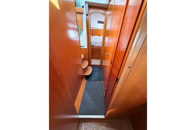Slide: The Image of Interior hallway of 2005 Lagoon 380 S2 catamaran with wooden finish and cozy cabin view. - 57