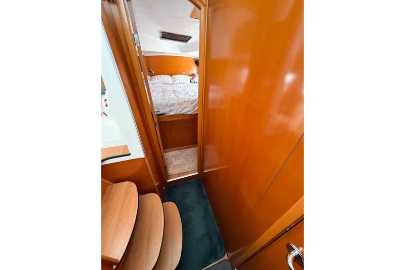 Slide: The Image of Interior view of 2005 Lagoon 380 S2 yacht cabin with wooden finish and cozy bedding. - 58