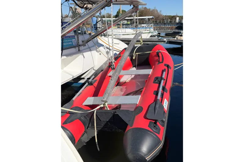 Slide: The Image of Red inflatable boat docked beside a 2005 Lagoon 380 S2 yacht. - 6