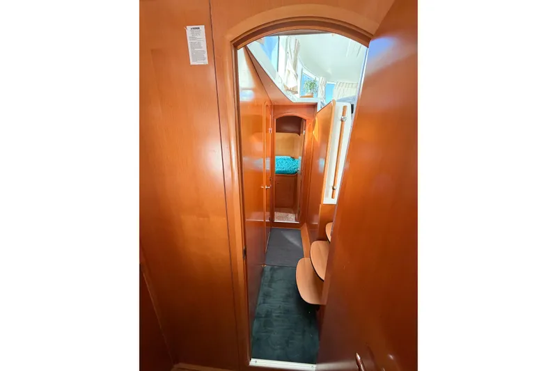 Slide: The Image of Interior view of 2005 Lagoon 380 S2 yacht, featuring wooden cabinetry and cozy sleeping area. - 62