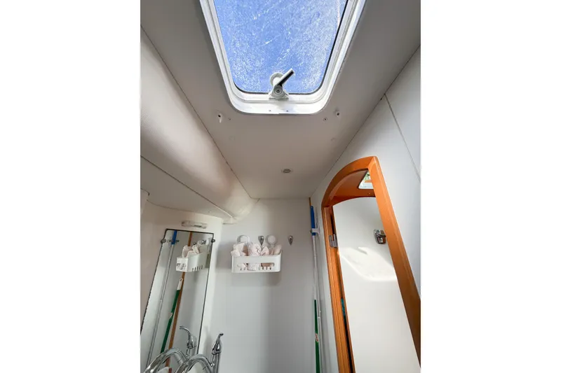 Slide: The Image of Interior of 2005 Lagoon 380 S2 yacht bathroom with skylight and wooden door. - 66