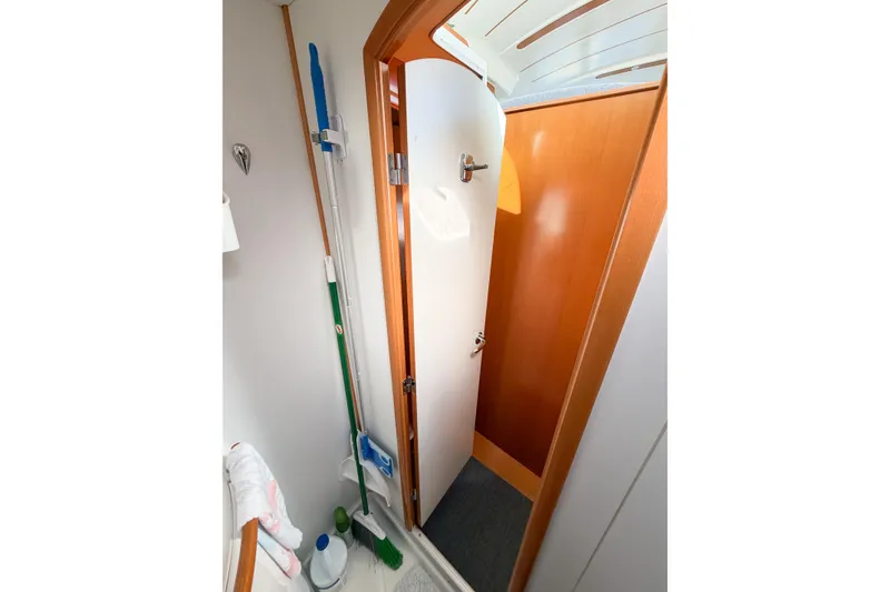 Slide: The Image of Interior of 2005 Lagoon 380 S2 yacht showing a compact storage area with cleaning supplies. - 67