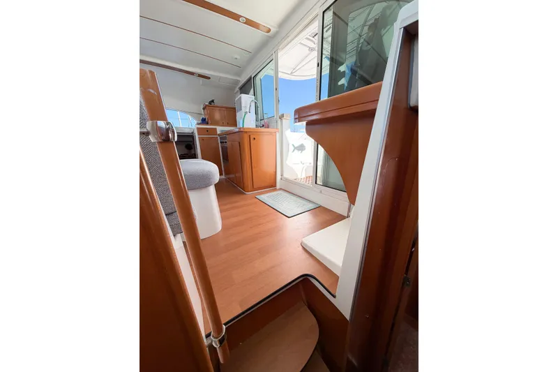 Slide: The Image of Interior view of 2005 Lagoon 380 S2 catamaran, featuring wooden flooring and modern furnishings. - 69
