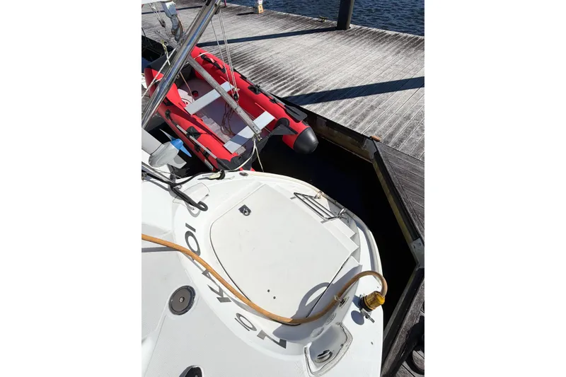 Slide: The Image of 2005 Lagoon 380 S2 catamaran docked with red inflatable boat nearby. - 7