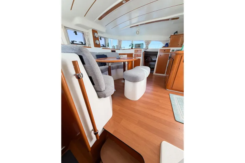 Slide: The Image of Interior of 2005 Lagoon 380 S2 catamaran with wooden flooring and cozy seating area. - 70