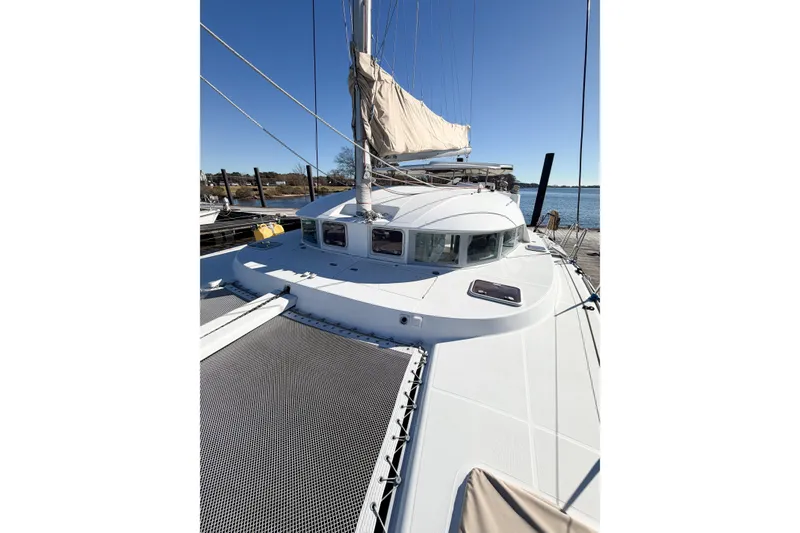 Slide: The Image of 2005 Lagoon 380 S2 catamaran docked, showcasing sleek design and spacious deck. - 80