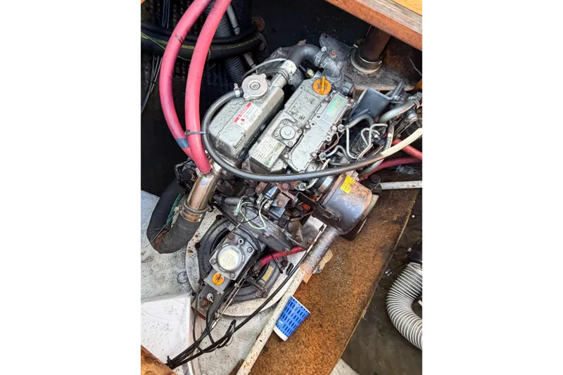 Slide: The Image of Engine compartment of a 2005 Lagoon 380 S2 catamaran with visible hoses and components. - 85