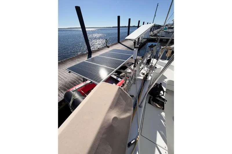 Slide: The Image of 2005 Lagoon 380 S2 catamaran with solar panels docked by the water. - 87