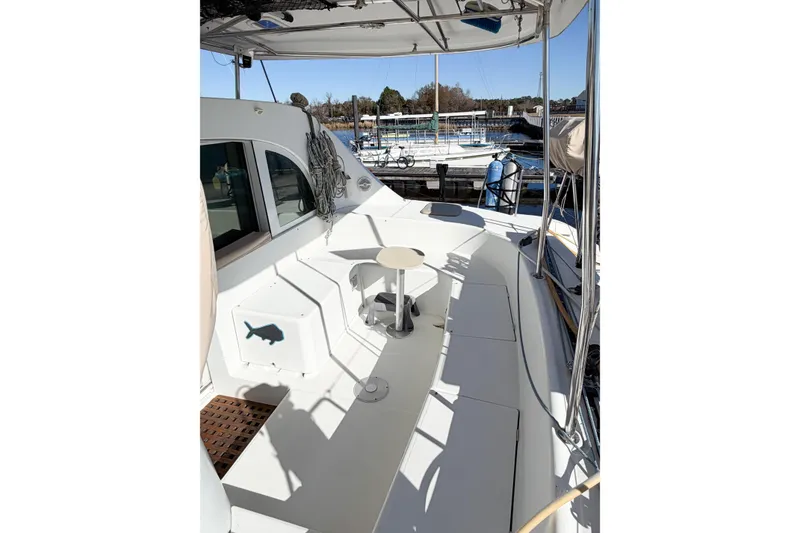 Slide: The Image of 2005 Lagoon 380 S2 catamaran deck with seating and marina view. - 9