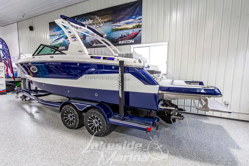 Slide: The Image of 2026 Chaparral SSX 6 boat in showroom, blue and white design on trailer. - 4