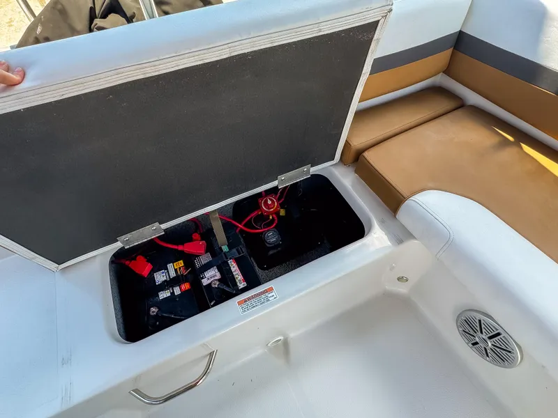 Slide: The Image of 2023 Starcraft SVX 190 OB boat battery compartment with open hatch and seating area. - 7