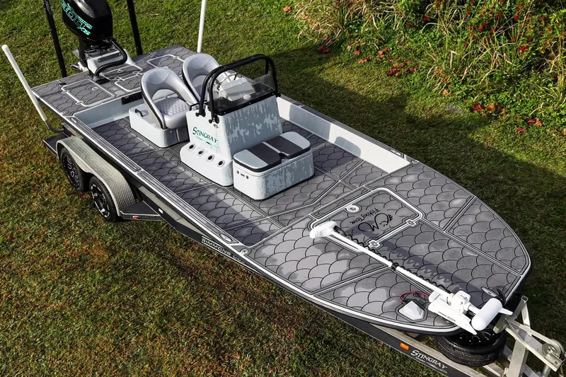 Slide: The Image of 2014 SCB Stingray Sport 25 boat on grass, featuring sleek design and modern seating. - 19